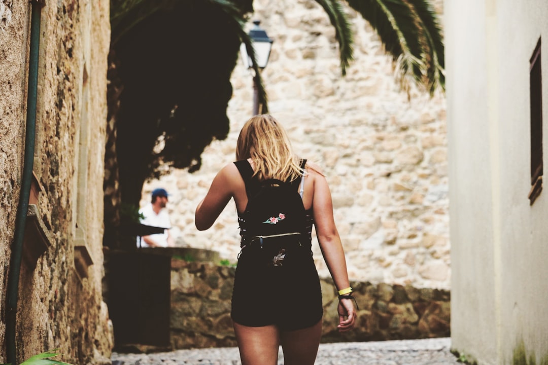 woman walking on alley while facing backwards