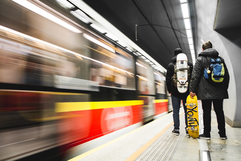 time-lapse photo of two men standing near train