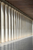 inline white concrete pillars with empty hallway