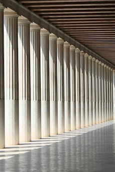 inline white concrete pillars with empty hallway
