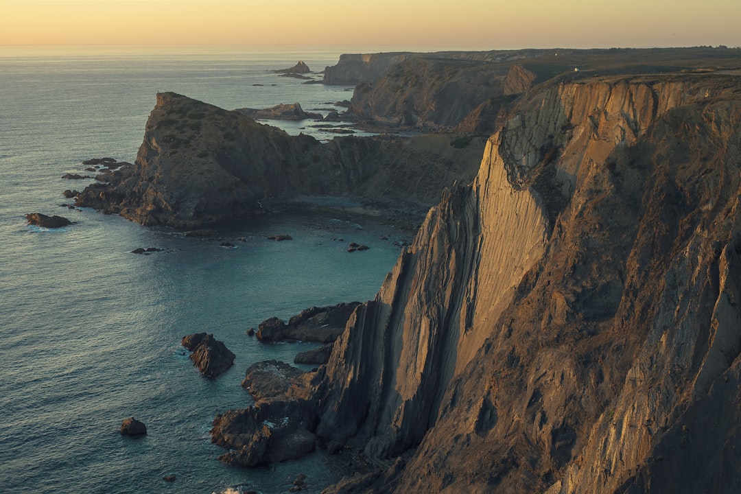 aerial photography of mountain near sea, Arrifana sunset