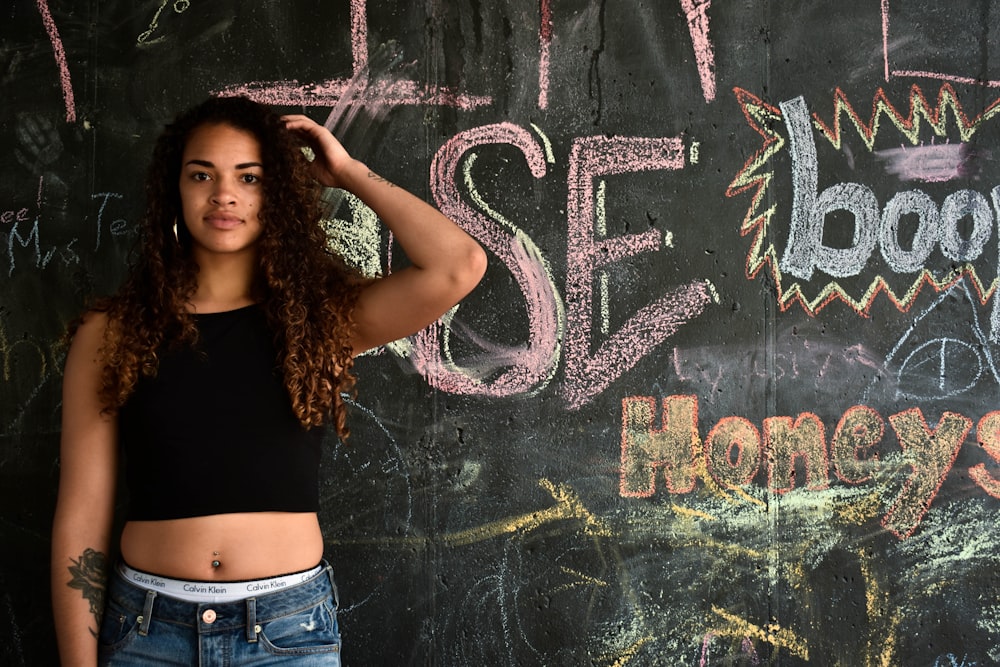 woman standing near wall with graffiti