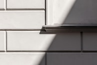 Textured GRC façade segments arranged in vertical and horizontal patterns creating dynamic shadows.