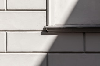 Textured GRC façade segments arranged in vertical and horizontal patterns creating dynamic shadows.