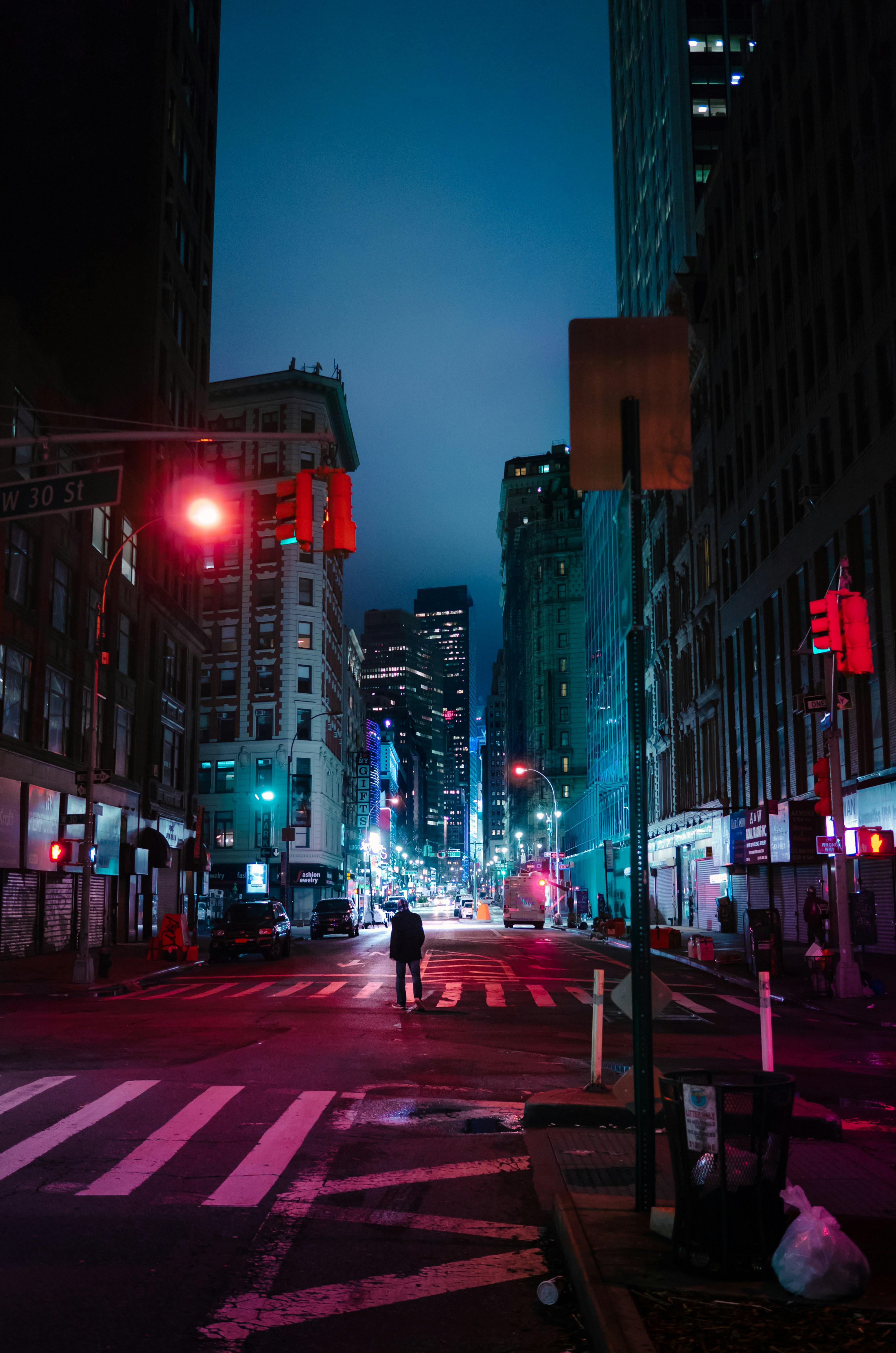 person standing center of road near buildings