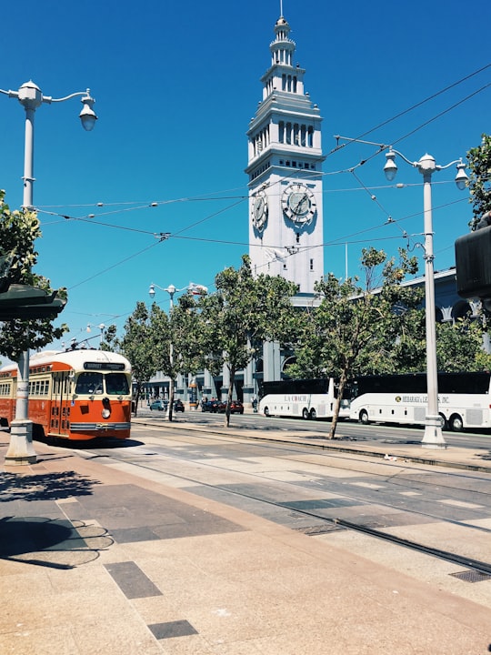white bus near white clock tower in Ferry Building United States