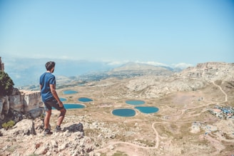 man standing on rocks looking down