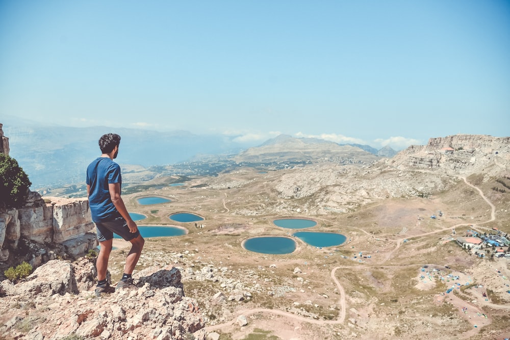 man standing on rocks looking down