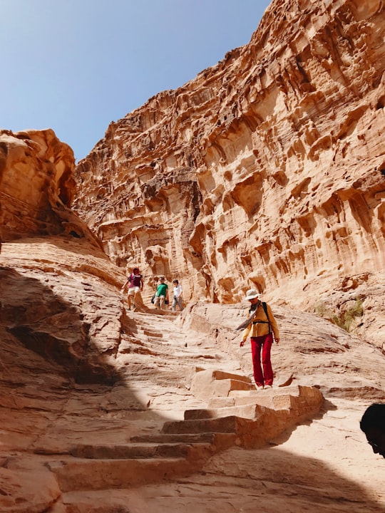 man standing near mountain peak in Petra Jordan