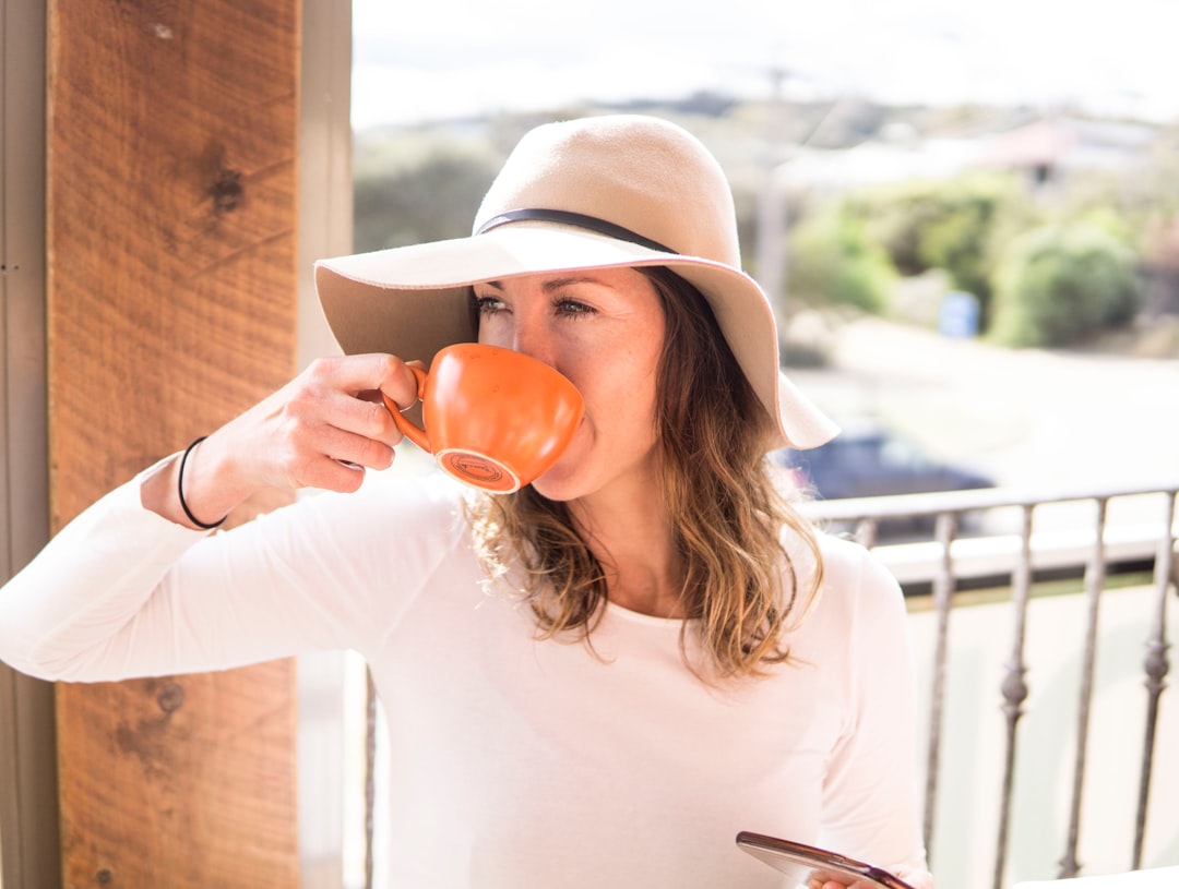 woman sipping from her orange cup