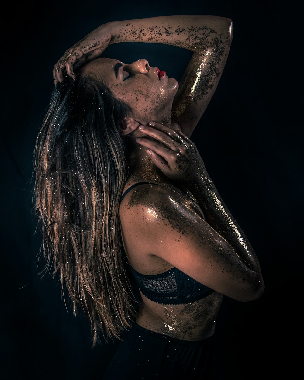 photo of woman raising head covered with gray sequin