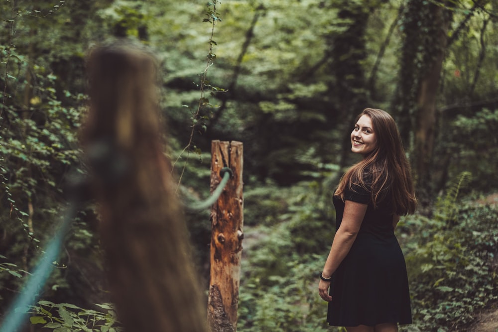 woman standing beside post