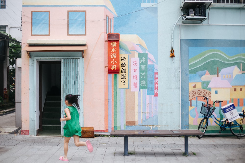 girl running beside bench