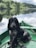 black dog sitting on boat on body of water