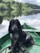 black dog sitting on boat on body of water
