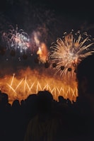 Festive crowd enjoying a dazzling fireworks display with glowing faces.