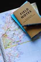 A close-up of a detailed map with travel notes and a compass resting on it.