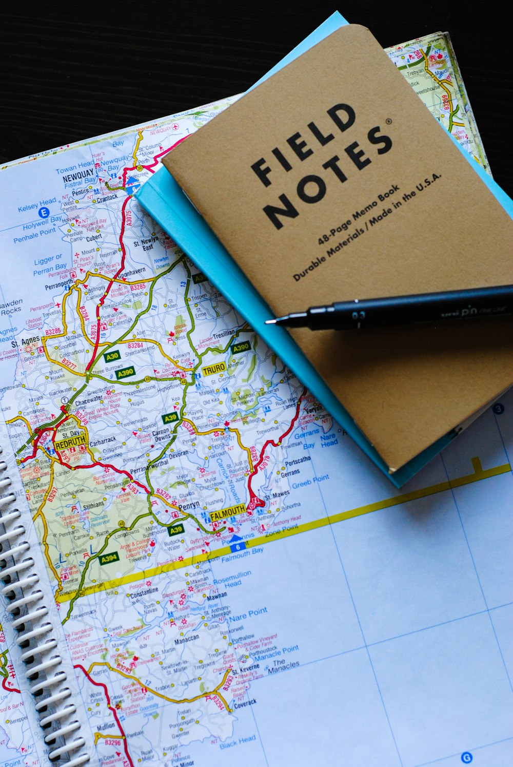 stylo gel noir sur le carnet de notes de terrain