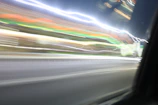 Abstract light trails from a moving camera in a night cityscape.