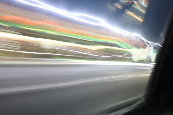 An artistic shot blending light trails and abstract shapes in a nighttime urban setting.