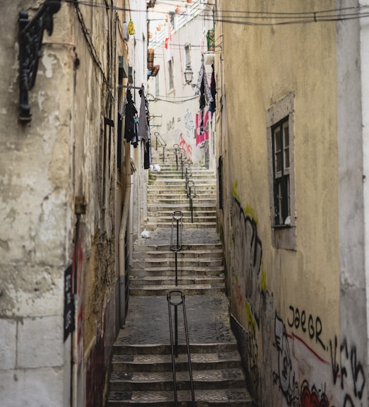 a narrow alleyway with graffiti on the walls