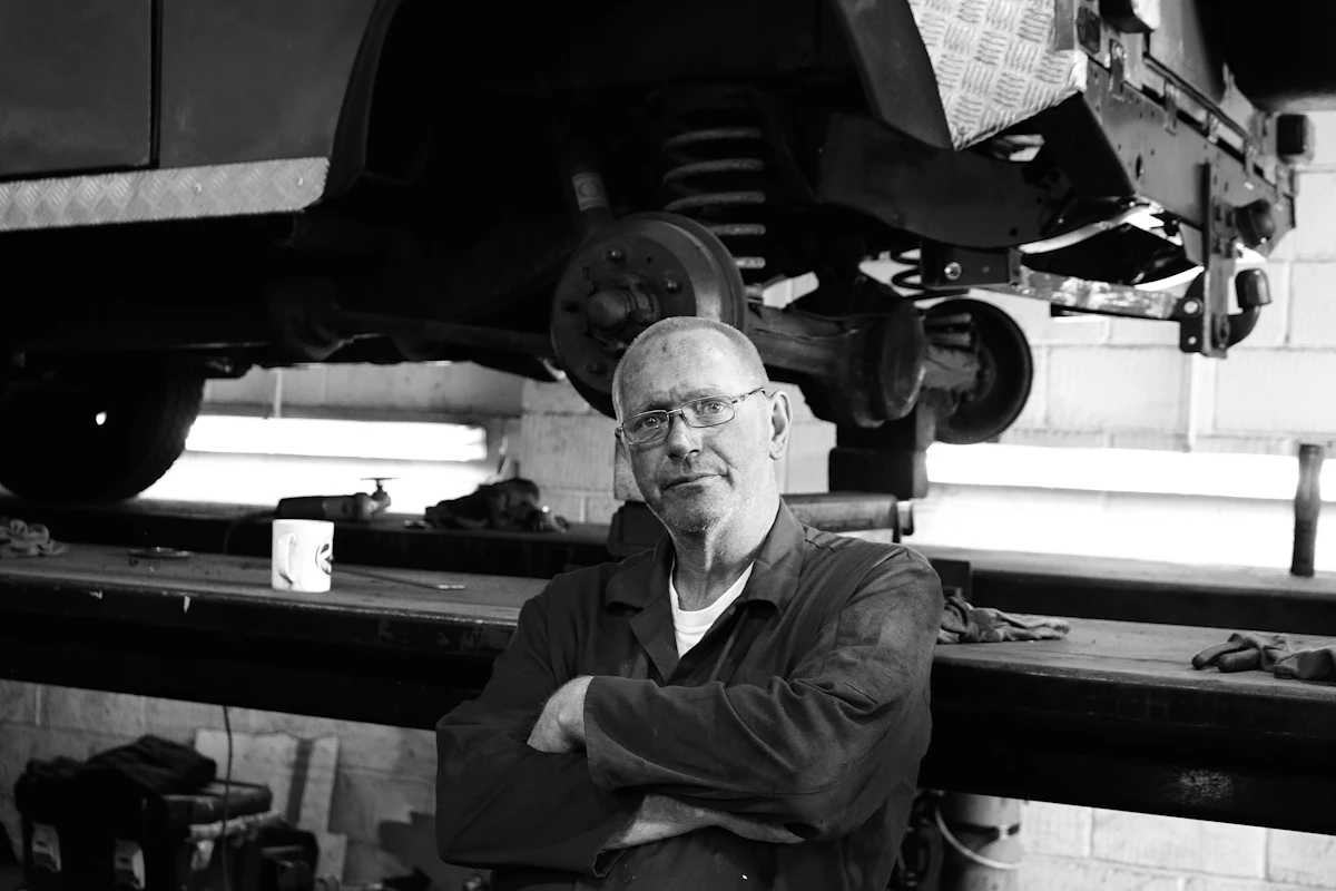 Czarno-białe zdjęcie mechanika przy pracy w warsztacie