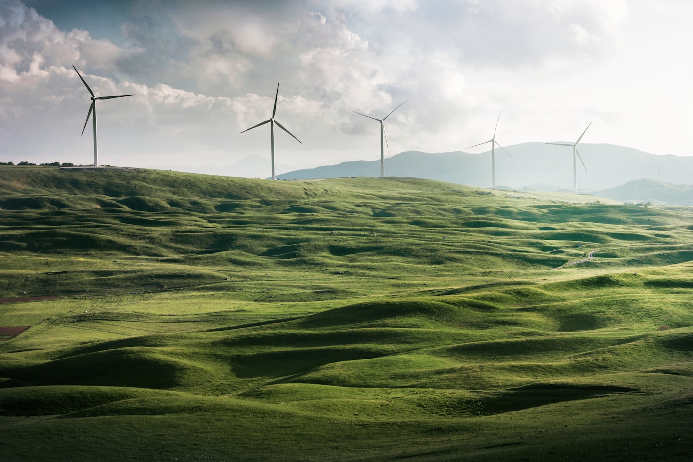 Wind turbines against sunset sky