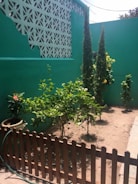 A small fence surrounding a landscaped area with plants.