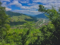 A charming valley surrounded by rolling hills and a distant river.