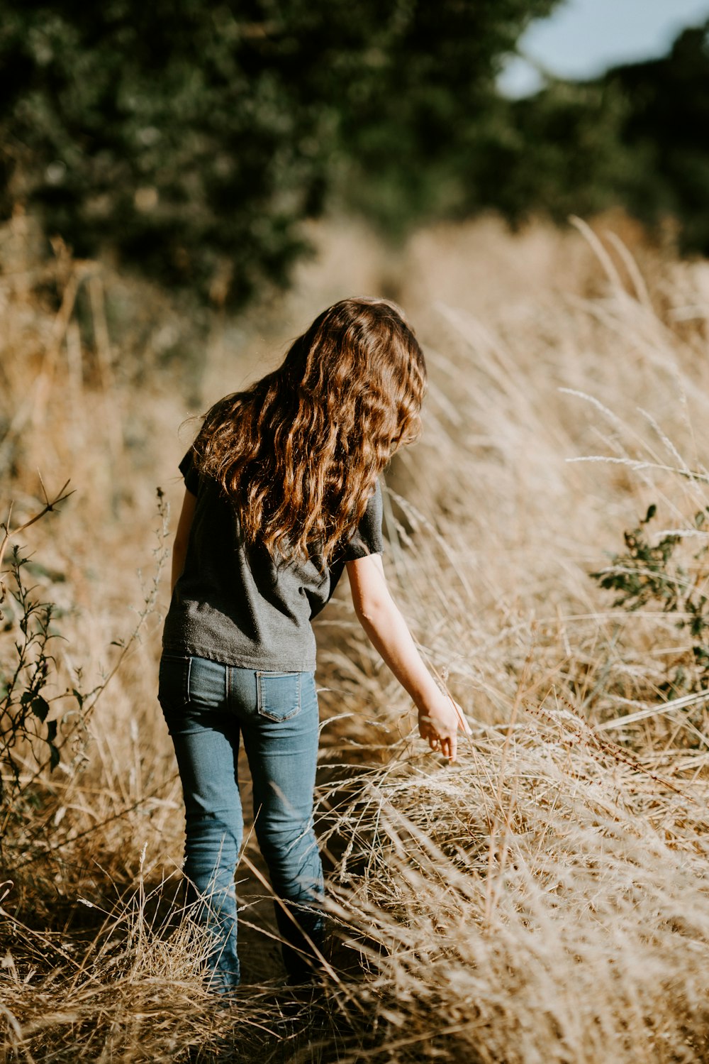 woman standing in middle of grass field