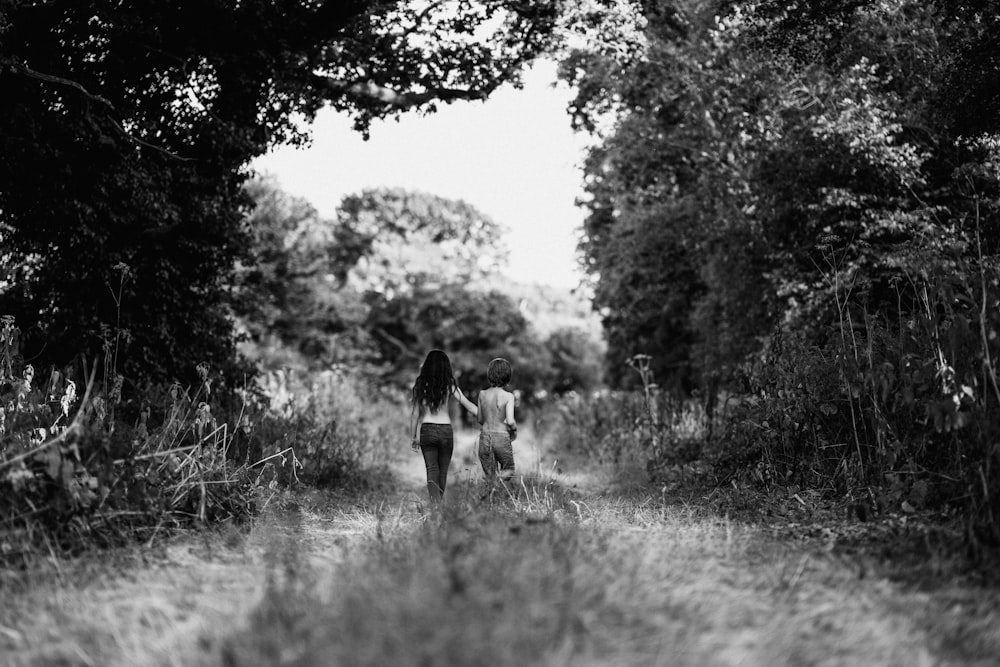 man and woman walking on grass field