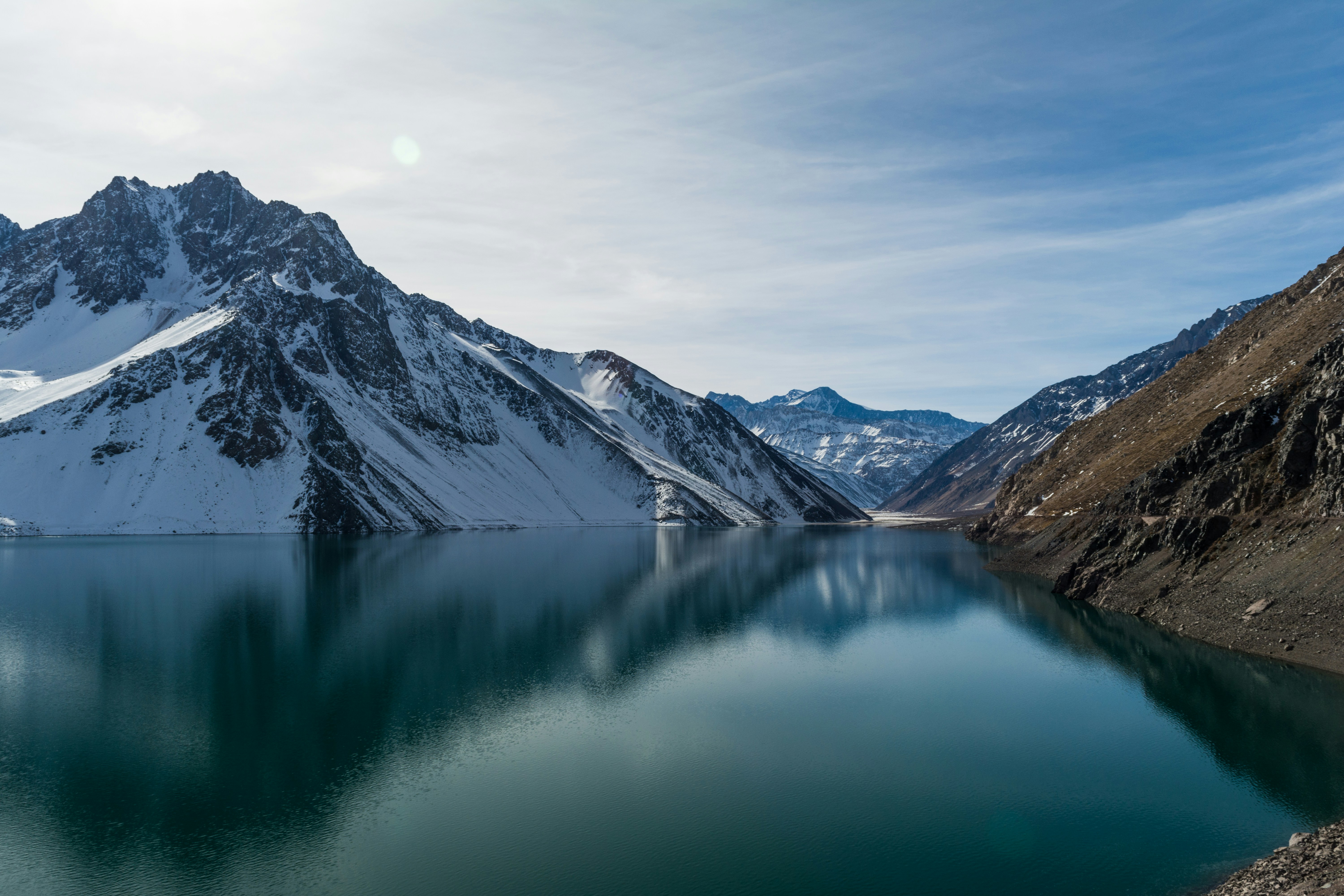 snow-covered mountain near body of water