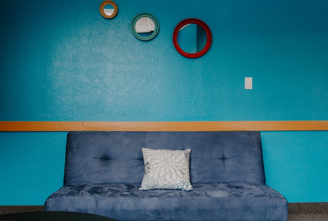 blue 3-seat sofa with throw pillow
