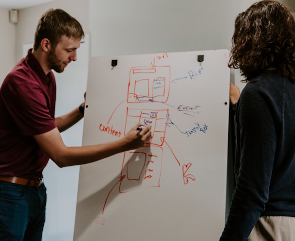 man drawing on dry-erase board