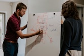 man drawing on dry-erase board