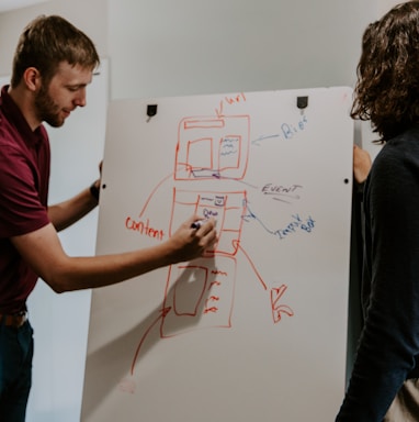 man drawing on dry-erase board