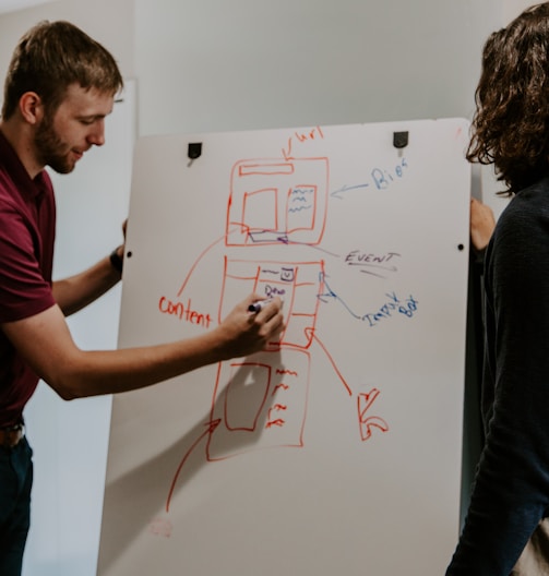 man drawing on dry-erase board