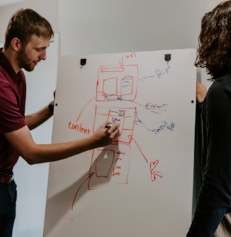 man drawing on dry-erase board