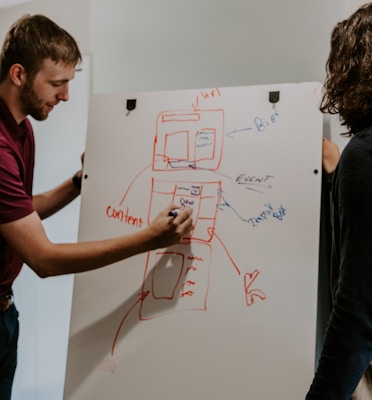 man drawing on dry-erase board