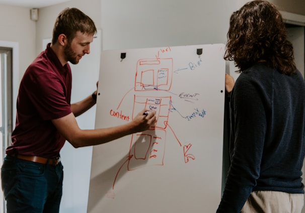 man drawing on dry-erase board