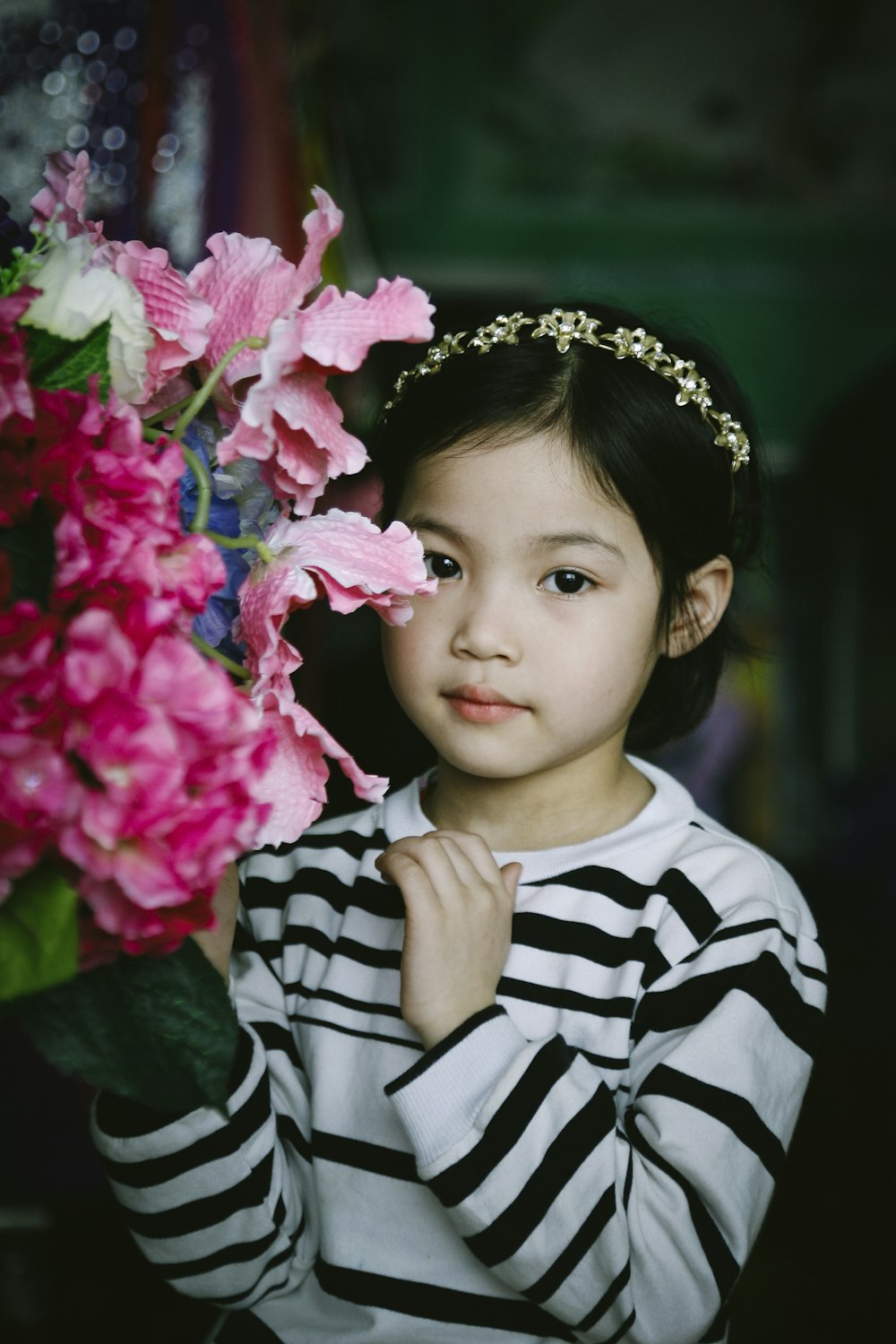 selective focus photography of girl beside pink petaled flowers