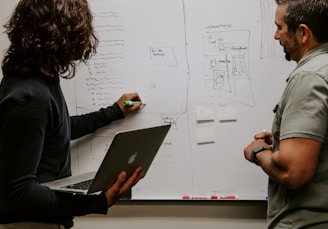 man wearing gray polo shirt beside dry-erase board