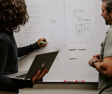 man wearing gray polo shirt beside dry-erase board