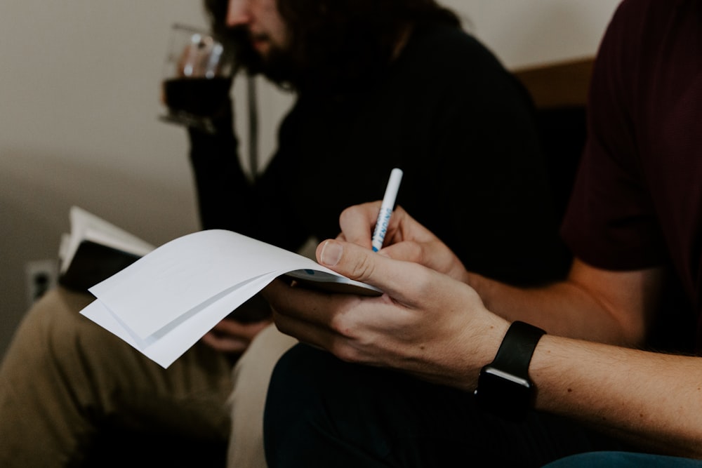 hombre escribiendo al lado del hombre