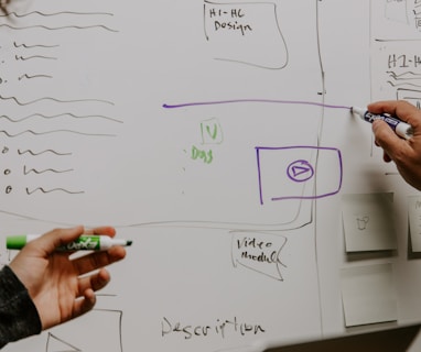 two people drawing on whiteboard