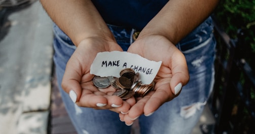 person showing both hands with make a change note and coins