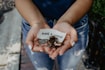person showing both hands with make a change note and coins