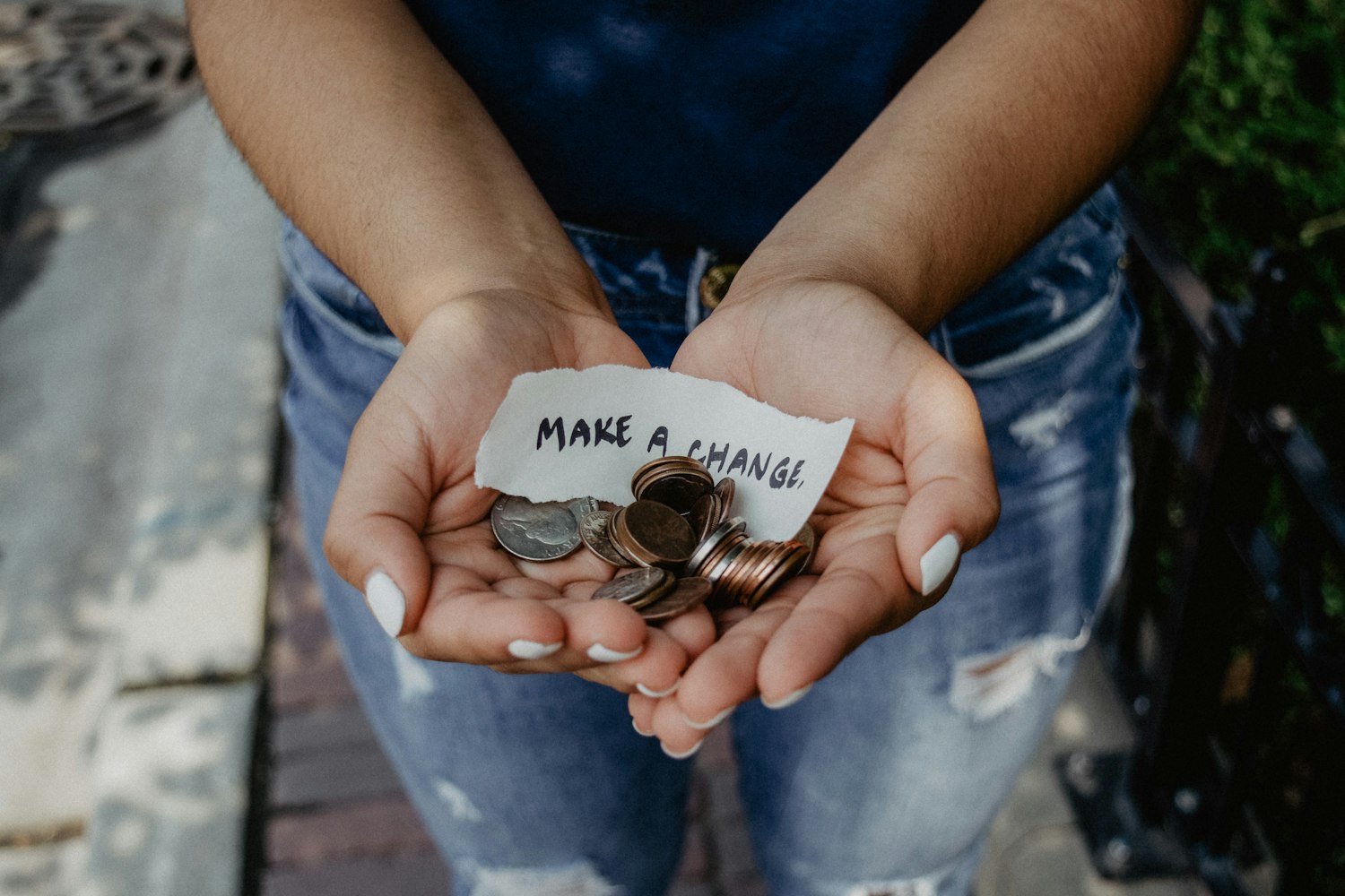 Hands holding coins and a plant