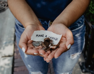 person showing both hands with make a change note and coins