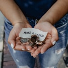 person showing both hands with make a change note and coins